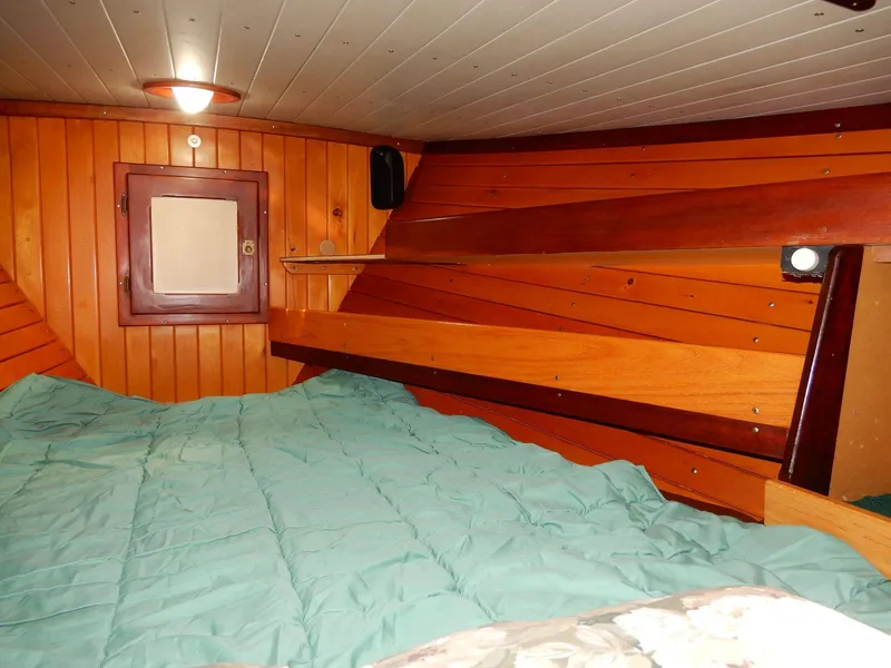 Slide: The Image of Cozy cabin interior of 1977 Ted Brewer Jason Pilothouse Offshore with wooden paneling and bedding. - 6