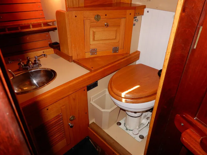 Slide: The Image of 1977 Ted Brewer Jason Pilothouse Offshore yacht bathroom with wooden cabinetry and marine toilet. - 7