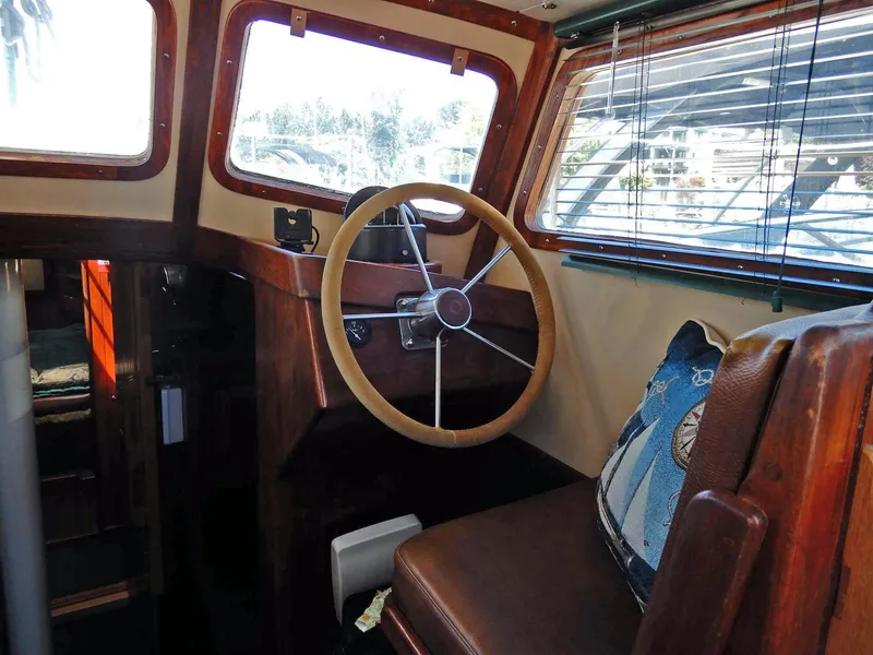 Slide: The Image of 1977 Ted Brewer Jason Pilothouse Offshore interior with wooden steering wheel and nautical decor. - 9