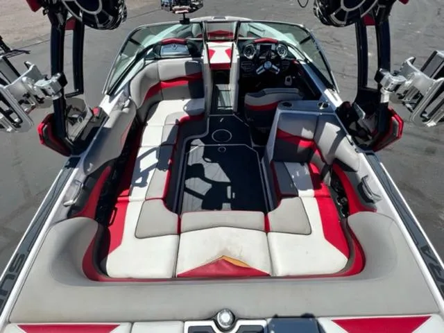 Slide: The Image of 2014 Supra SC350-550 boat interior with red and white seating, advanced dashboard, and wakeboard racks. - 11