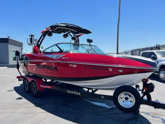 Slide: The Image of 2014 Supra SC350-550 red boat on trailer in parking lot. - 4