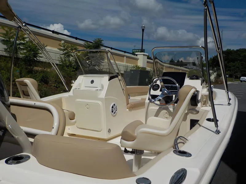 Slide: The Image of 2024 Scout 195 Sport Dorado boat interior with beige seating and steering console. - 10