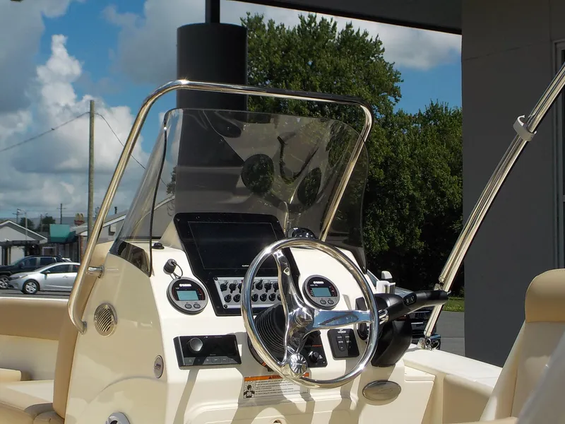 Slide: The Image of 2024 Scout 195 Sport Dorado boat dashboard with steering wheel and controls. - 11