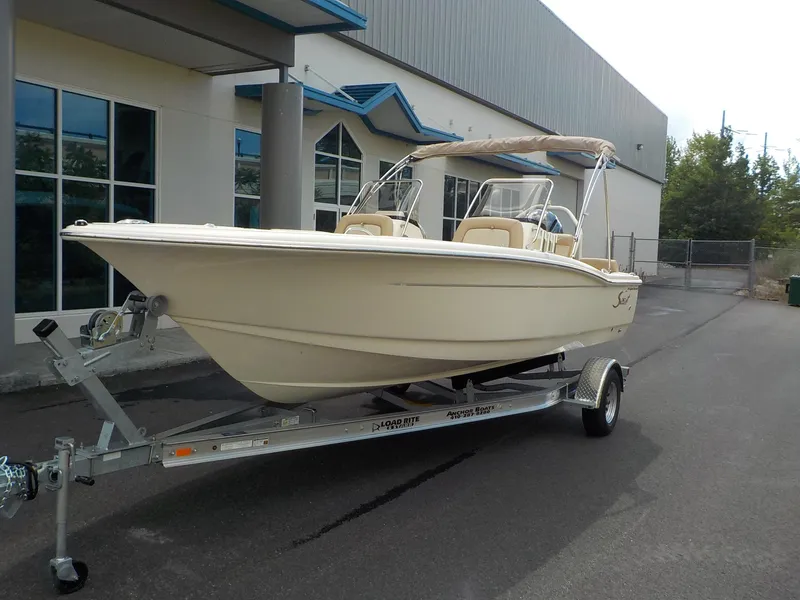 Slide: The Image of 2024 Scout 195 Sport Dorado boat on trailer outside a building. - 7