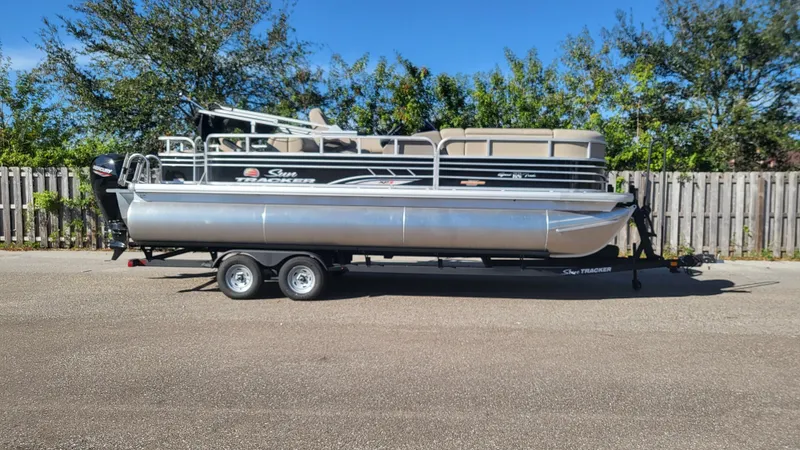 Slide: The Image of 2023 Sun Tracker SportFish 22 XP3 pontoon boat on trailer, parked outdoors. - 4