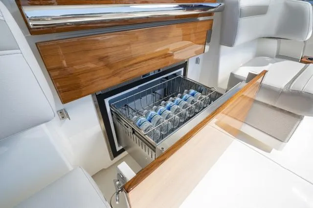 Slide: The Image of Built-in cooler drawer on the 2024 Tiara Yachts 38LS, stocked with bottled water. - 12