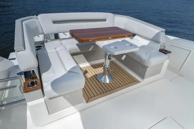 Slide: The Image of Luxury seating area on 2024 Tiara Yachts 38LS with wooden table and cup holders. - 14
