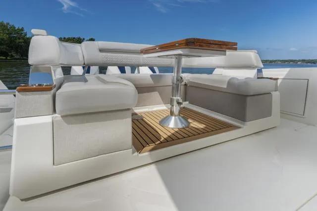 Slide: The Image of Luxurious seating area on the 2024 Tiara Yachts 38LS with a wooden table. - 19