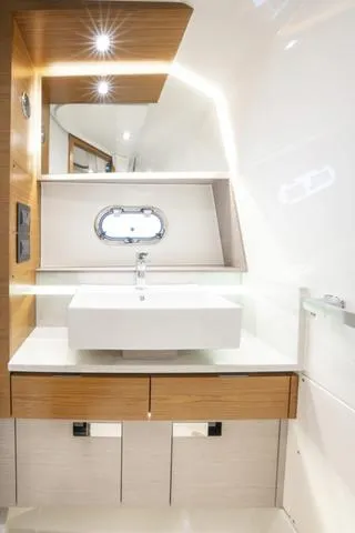 Slide: The Image of 2024 Tiara Yachts 38LS bathroom with modern sink and wooden cabinetry. - 22