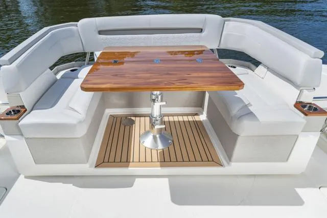 Slide: The Image of Tiara Yachts 38LS 2024 model with luxurious seating and wooden table on deck. - 9
