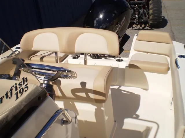 Slide: The Image of 2023 Scout 195 Sportfish boat interior with beige seating and steering wheel. - 7