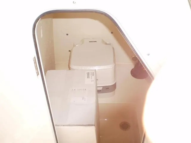 Slide: The Image of 2023 Scout 195 Sportfish boat interior storage compartment with portable toilet. - 8