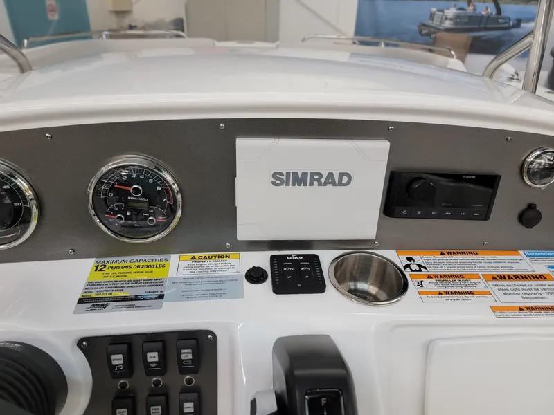 Slide: The Image of 2024 Hurricane SunDeck Sport CC 231 OB boat dashboard with steering wheel and controls. - 15