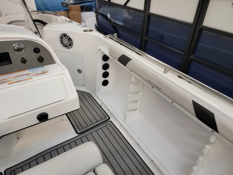 Slide: The Image of 2024 Hurricane SunDeck Sport CC 231 OB boat interior with vending machines in the background. - 19