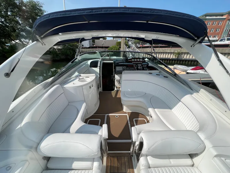 Slide: The Image of 2004 Cobalt 360 boat with white leather seating and blue canopy. - 12