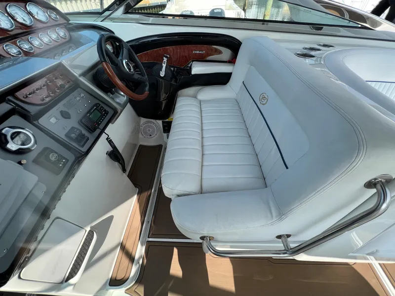 Slide: The Image of 2004 Cobalt 360 boat interior with white leather seating and control panel. - 16