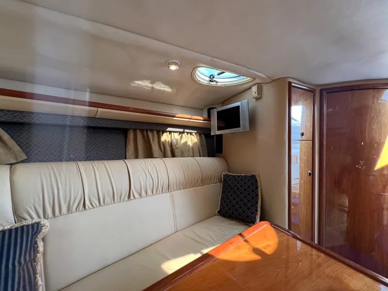 Slide: The Image of Interior of a 2004 Cobalt 360 boat with beige seating and a small TV. - 25