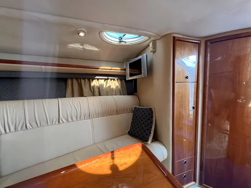 Slide: The Image of Interior cabin of a 2004 Cobalt 360 boat with seating, TV, and storage. - 26