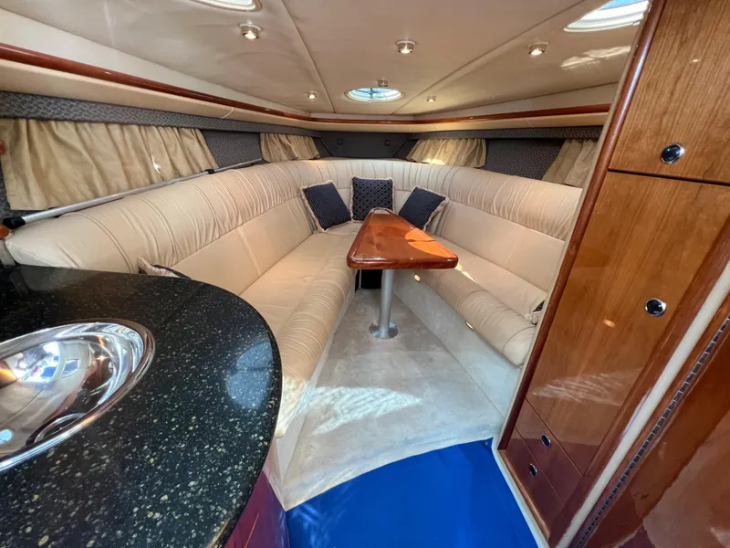 Slide: The Image of Luxurious interior of a 2004 Cobalt 360 boat with plush seating and wooden table. - 27