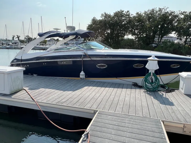 Slide: The Image of 2004 Cobalt 360 boat docked at a marina with trees in the background. - 4