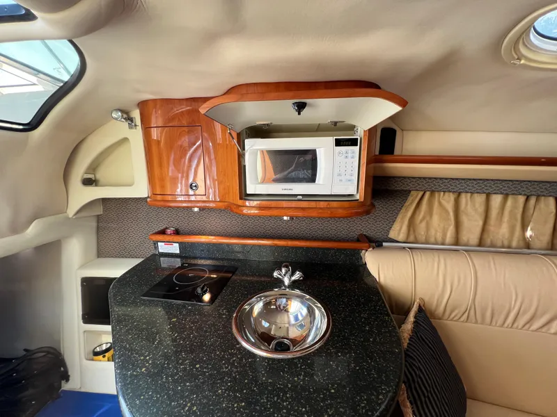 Slide: The Image of 2004 Cobalt 360 boat interior with kitchenette, microwave, sink, and stove. - 41