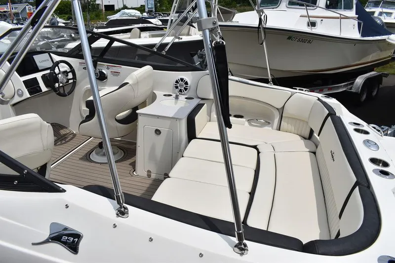 Slide: The Image of 2023 Stingray 231DC boat interior with white seating and modern dashboard. - 11