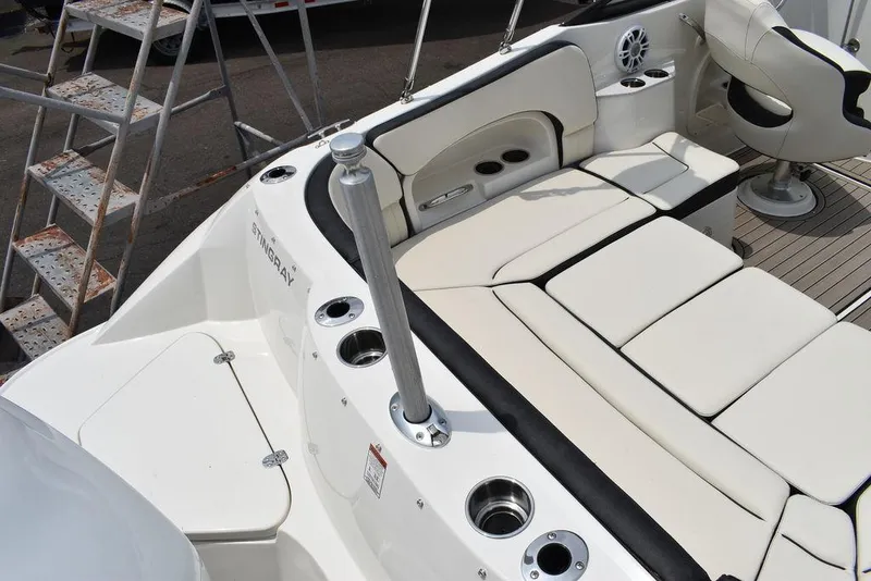 Slide: The Image of 2023 Stingray 231DC boat interior with white seating and cup holders. - 17