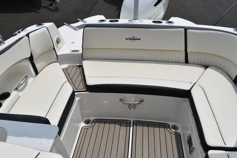 Slide: The Image of 2023 Stingray 231DC boat with white and black seating and teak flooring. - 20