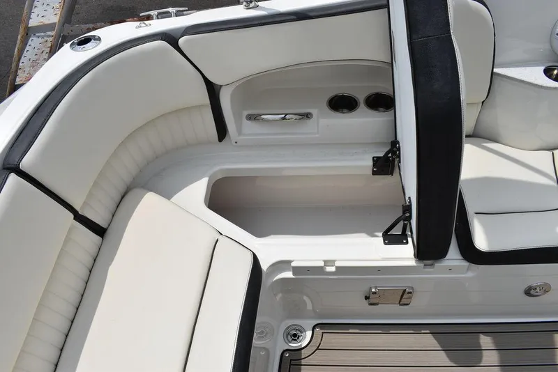 Slide: The Image of 2023 Stingray 231DC boat interior with white cushioned seating and storage compartment. - 22