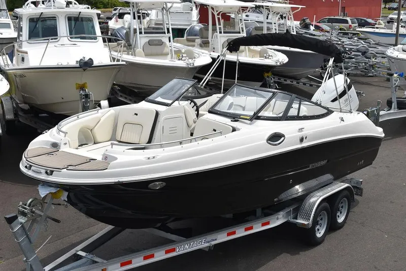 Slide: The Image of 2023 Stingray 231DC boat on a trailer, surrounded by other boats in a marina. - 3