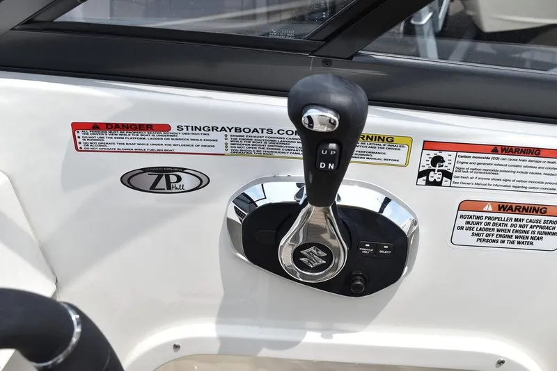 Slide: The Image of 2023 Stingray 231DC boat throttle control with warning labels. - 31