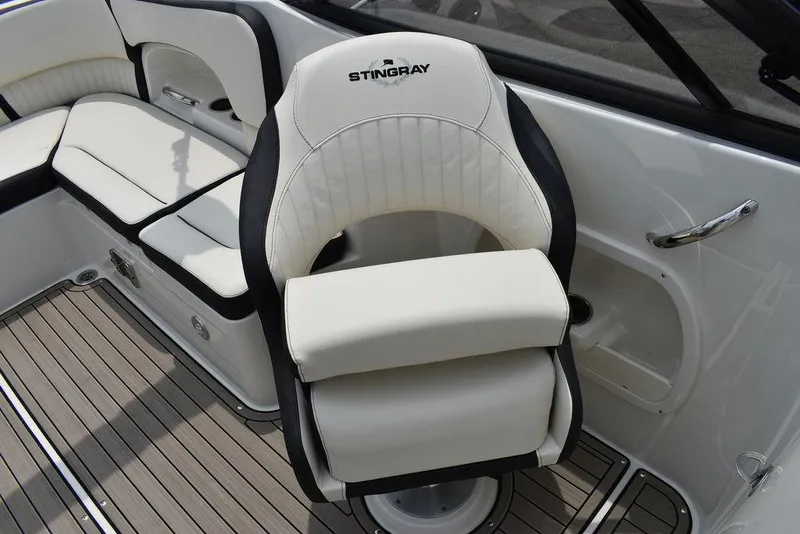Slide: The Image of 2023 Stingray 231DC boat interior with white leather seating and wood flooring. - 34