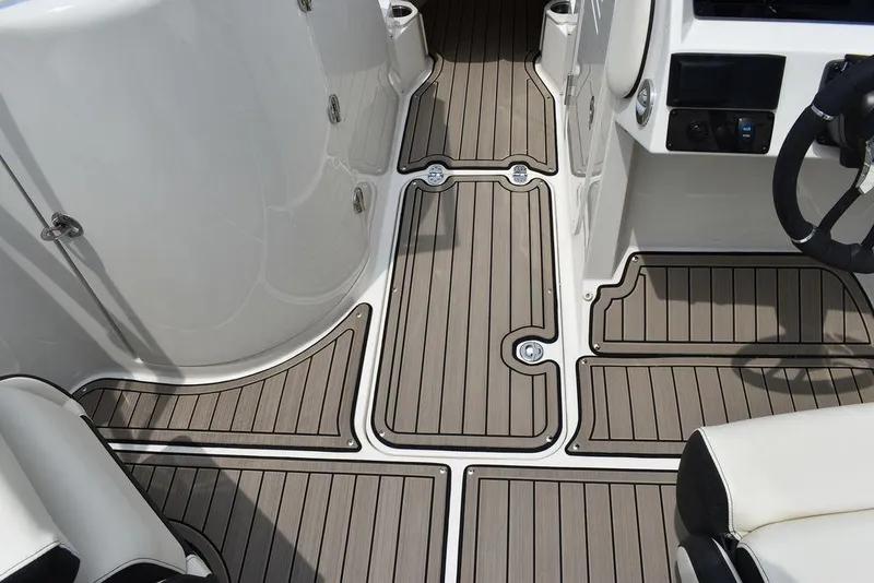 Slide: The Image of 2023 Stingray 231DC boat interior with teak-style flooring and white seating. - 36