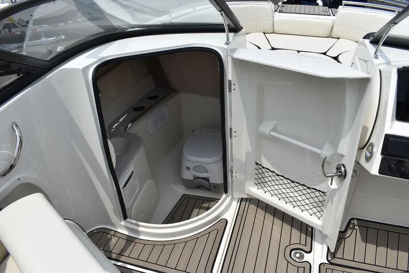Slide: The Image of 2023 Stingray 231DC boat interior with open door revealing compact toilet. - 38