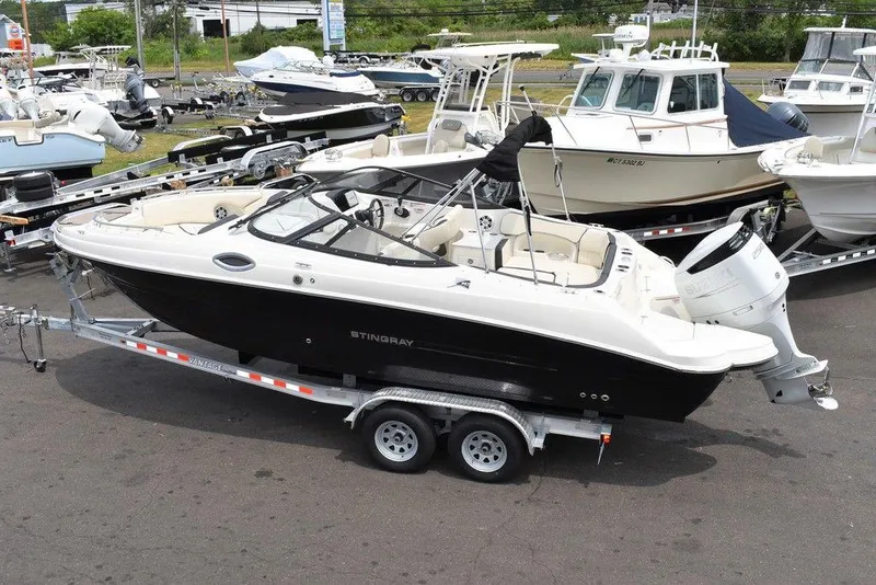 Slide: The Image of 2023 Stingray 231DC boat on a trailer in a marina. - 4