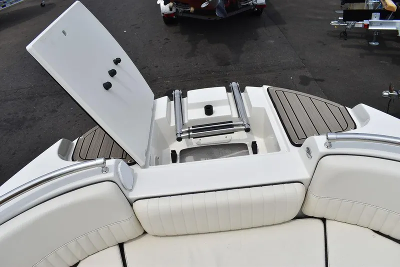 Slide: The Image of 2023 Stingray 231DC boat with open storage compartment and cushioned seating. - 49
