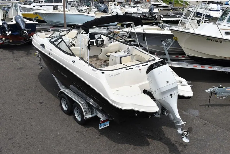 Slide: The Image of 2023 Stingray 231DC boat on a trailer in a marina. - 5