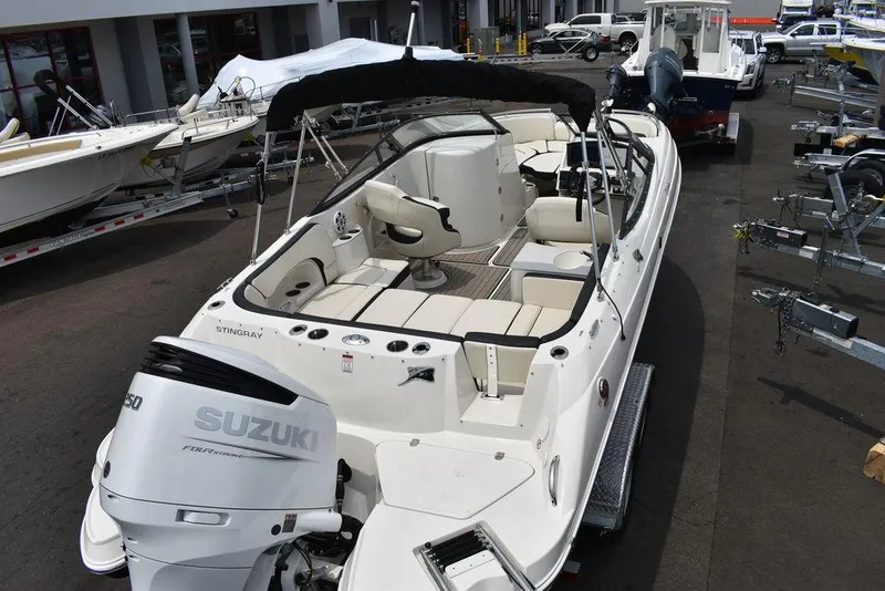 Slide: The Image of 2023 Stingray 231DC boat with Suzuki outboard motor in a marina. - 8