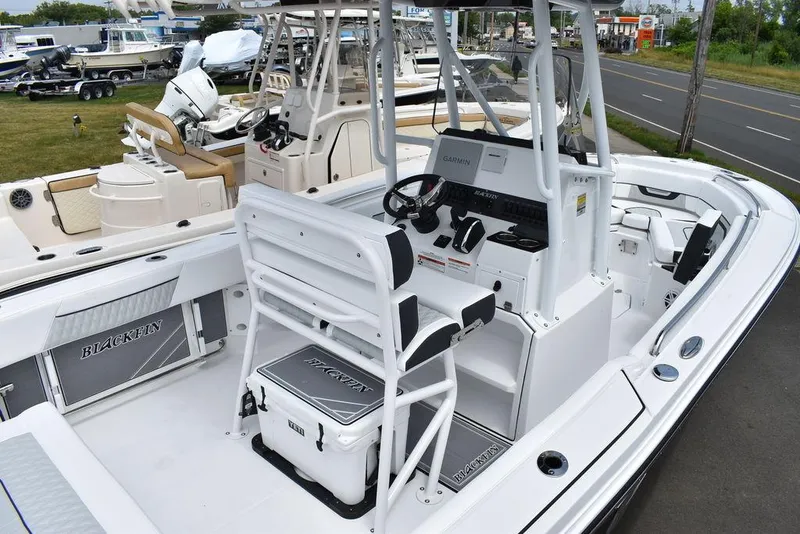 Slide: The Image of 2024 Blackfin 222CC boat interior with helm, seating, and storage compartments. - 10