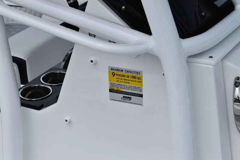 Slide: The Image of 2024 Blackfin 222CC boat capacity label, white interior, cup holders visible. - 13