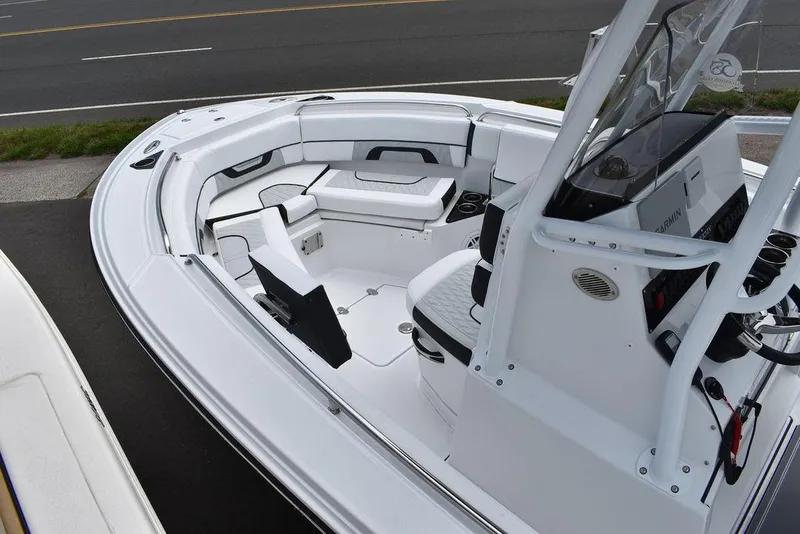 Slide: The Image of 2024 Blackfin 222CC boat interior with seating and console, docked near a road. - 19