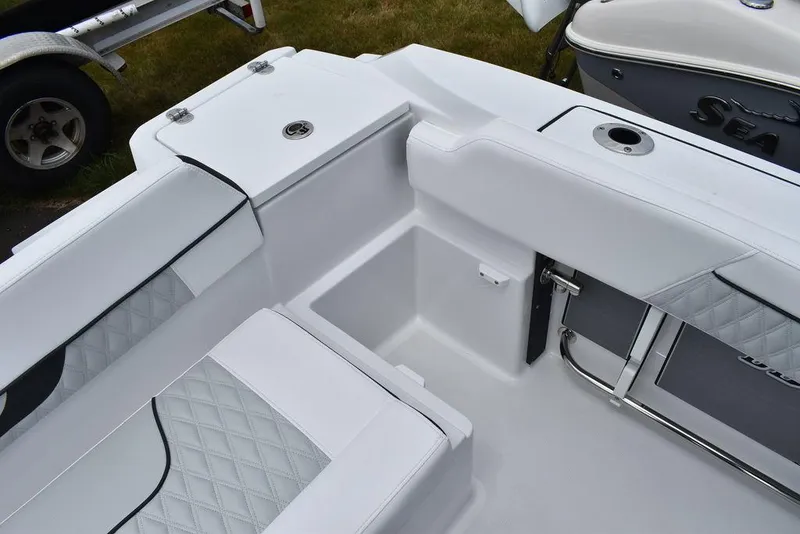 Slide: The Image of 2024 Blackfin 222CC boat interior with white cushioned seating and storage compartments. - 24