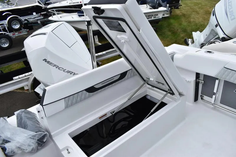 Slide: The Image of 2024 Blackfin 222CC boat with open storage compartment and Mercury engine. - 31