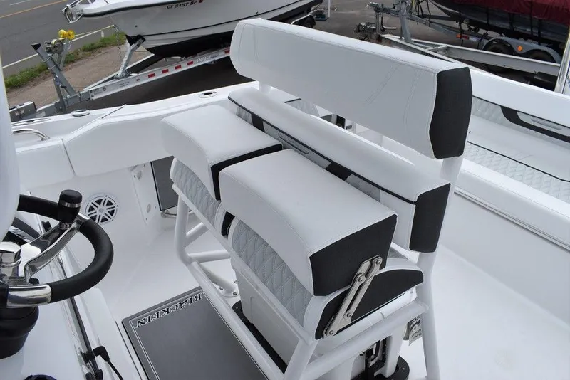 Slide: The Image of 2024 Blackfin 222CC boat interior with white seating and steering wheel. - 39