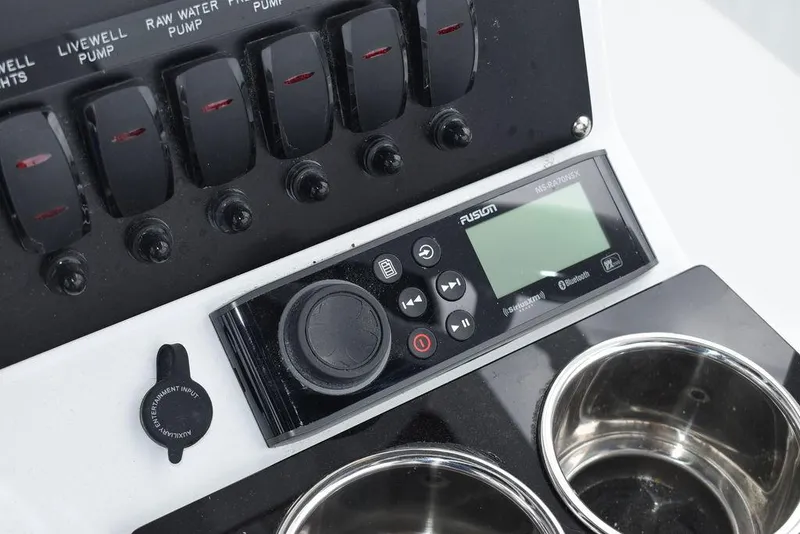 Slide: The Image of Control panel of 2024 Blackfin 222CC boat with switches and Fusion stereo system. - 44