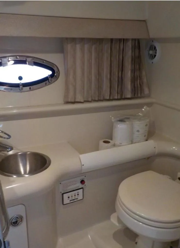 Slide: The Image of 2002 Formula 330 SS boat bathroom with sink, toilet, and porthole window. - 3