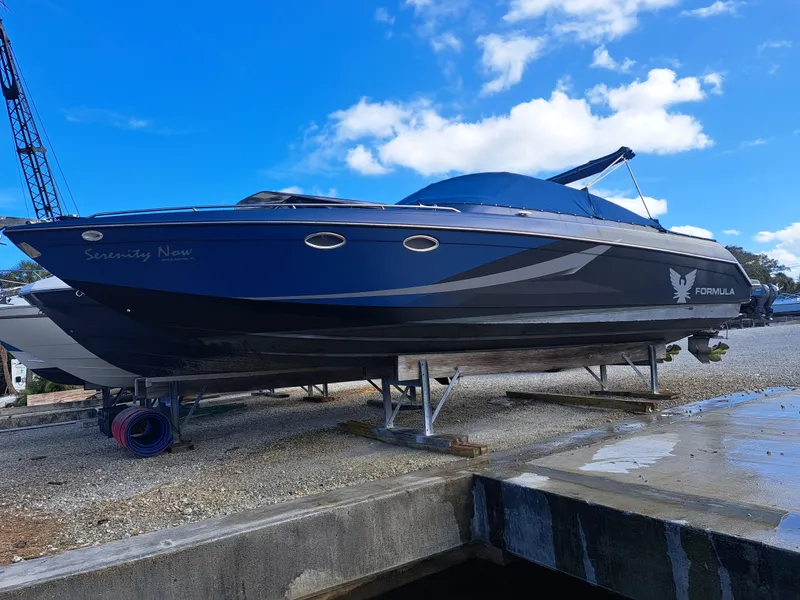 Slide: The Image of 2002 Formula 330 SS speedboat on dry dock with blue sky background. - 6