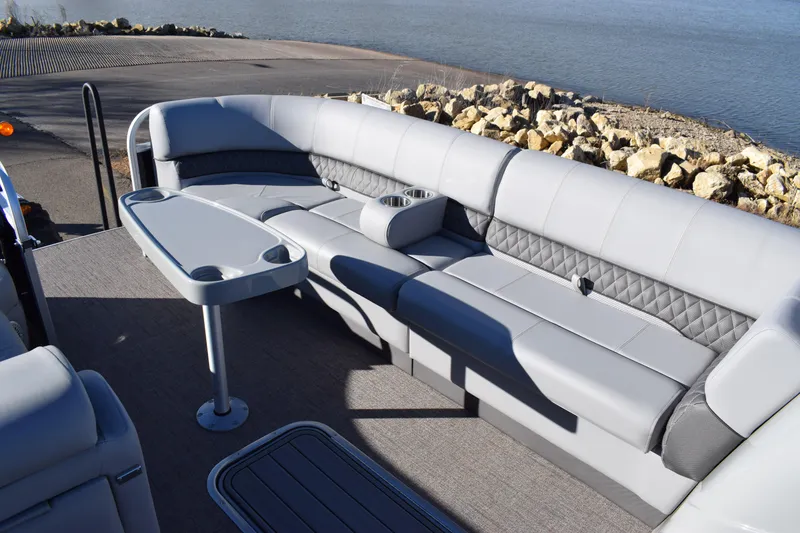 Slide: The Image of 2023 Ranger 223C boat interior with gray seating and table by the water. - 13