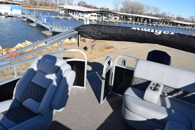 Slide: The Image of 2023 Ranger 223C pontoon boat with gray seating at a marina. - 17