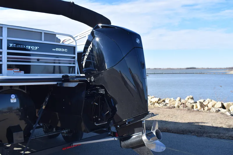 Slide: The Image of 2023 Ranger 223C boat with outboard motor by a lake. - 3
